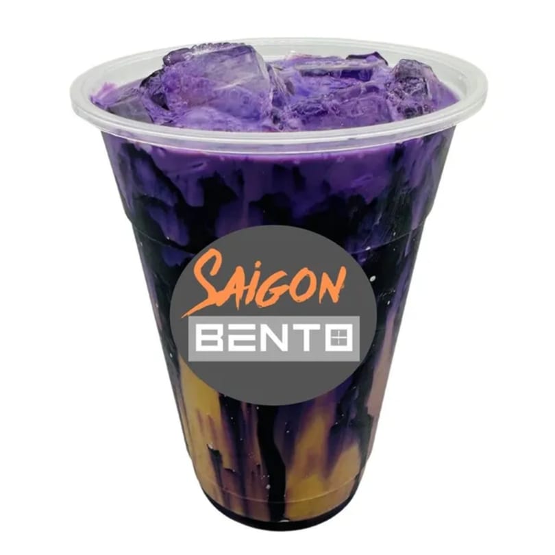 A Saigon Bento purple and gold layered drink with ice in a clear plastic cup.