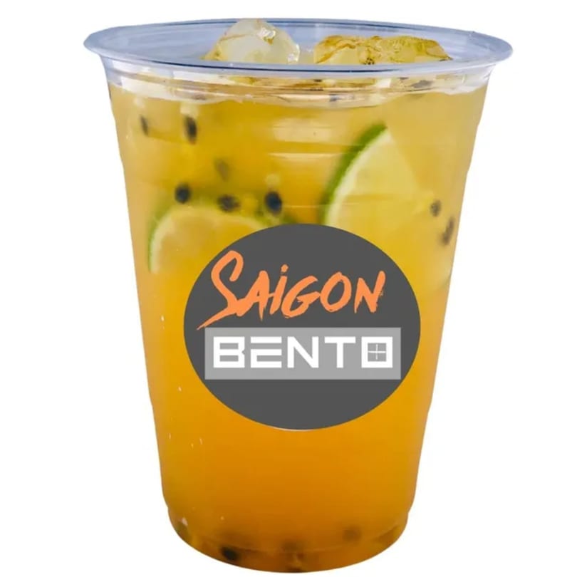 Saigon Bento's passion fruit drink with lime slices, ice, and passion fruit seeds in a clear cup.
